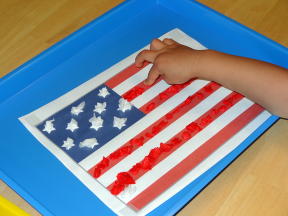 Sticky paper American flag craft - place crumpled tissue paper squares on contact paper to make this American flag sensory craft || Gift of Curiosity