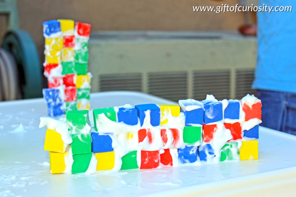 Kids can build structures with foam blocks and shaving cream to practice fine motor skills including spreading and stacking. Plus, the shaving cream adds an additional sensory element to this activity that kids love! #finemotor #sensory #handsonlearning || Gift of Curiosity