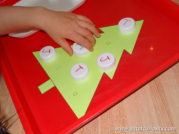 Christmas learning with milk caps: You can use milk caps to help kids learn letters and numbers, or adapt this activity to help kids learn other key skills as well! This is a fun and hands-on Christmas learning activity! || Gift of Curiosity