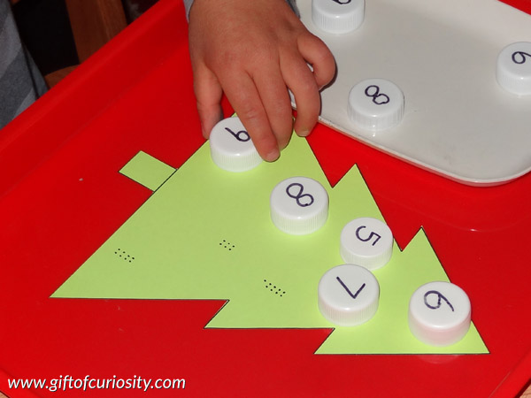 Christmas learning with milk caps: You can use milk caps to help kids learn letters and numbers, or adapt this activity to help kids learn other key skills as well! This is a fun and hands-on Christmas learning activity! || Gift of Curiosity