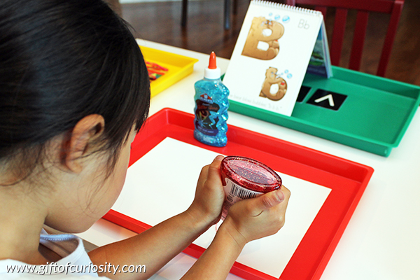 Use glitter glue to teach the alphabet while helping kids develop their fine motor skills. || Gift of Curiosity