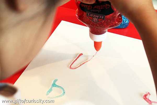 Use glitter glue to teach the alphabet while helping kids develop their fine motor skills. || Gift of Curiosity