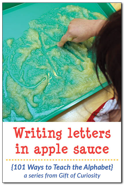 Writing letters in apple sauce. Combine letter learning with sensory play to help preschoolers learn the alphabet. I've gotta try this with my kids! || Gift of Curiosity