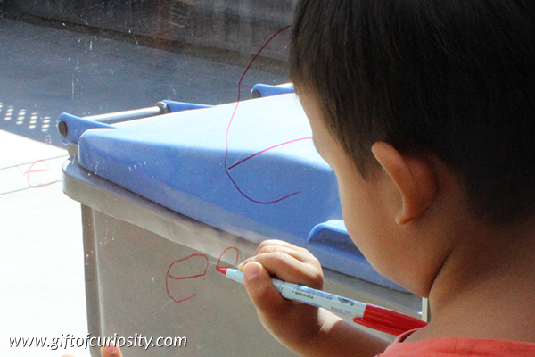 Window writing is a great way to get kids to practice their letters while also supporting the development of fine motor skills in a vertical plane. Learn about the special markers we use that make erasing the writing from the windows a breeze! || Gift of Curiosity