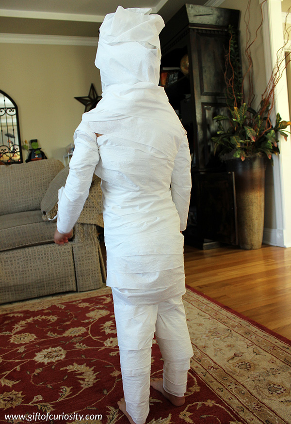 Halloween activities for kids: With a roll of toilet paper, you can turn your child into a mummy with this fun toilet paper mummies Halloween activity. || Gift of Curiosity