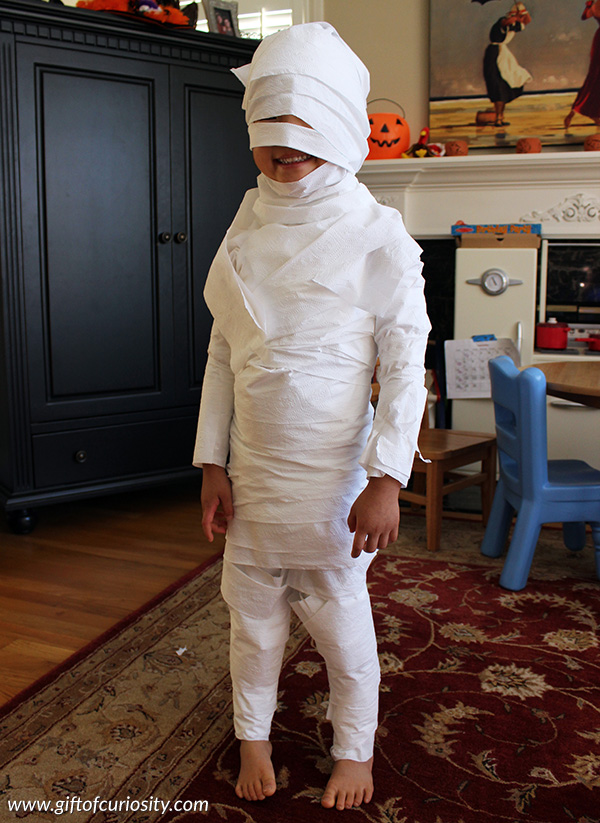 Halloween activities for kids: With a roll of toilet paper, you can turn your child into a mummy with this fun toilet paper mummies Halloween activity. || Gift of Curiosity