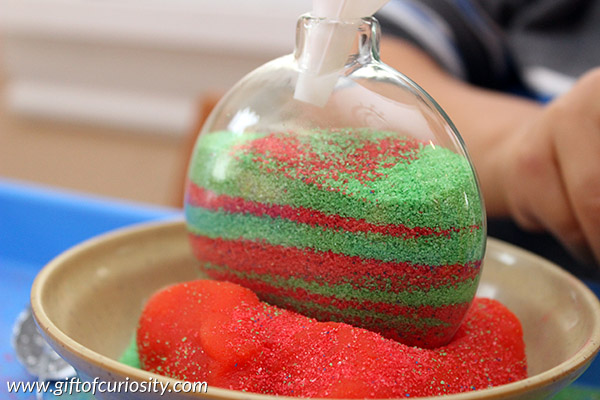 Kids can make their own sand-filled Christmas ornaments to decorate the tree this year. This is a great Christmas craft for kids who enjoy making their own ornaments. What a great idea to have something kid-made up on the tree! || Gift of Curiosity