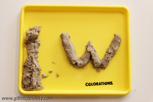 Making letters with kinetic sand is a great way to make learning letters into a fun sensory activity. Part of the 101 Ways to Teach the Alphabet series from Gift of Curiosity