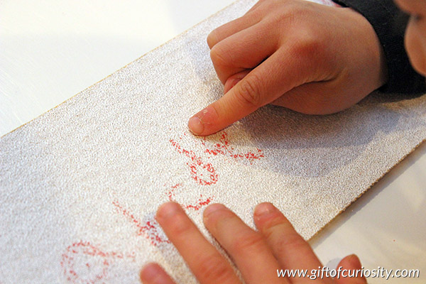 Writing letters on sandpaper combines letter learning with a fun and engaging sensory experience. What a fun way to teach the alphabet! || Gift of Curiosity