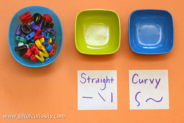 Sorting letters by their physical characteristics (e.g., straight and curvy lines) is a great way for young learners to attend to the shapes of letters {101 Ways to Teach the Alphabet} || Gift of Curiosity